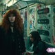 Nadia (Natasha Lyonne) looks confused on a graffiti-covered NYC subway car.